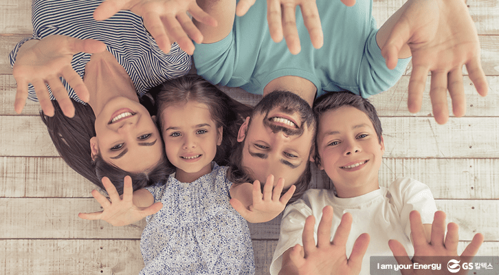 부모와 아이들이 함께 누워 행복한 표정을 짓고 있는 모습
