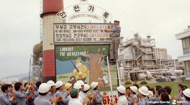 GS칼텍스 임직원들이 여수공장의 무사고 근무시간과 최장무사고 연근무시간이 적힌 판을 보며 박수를 치는 모습이 담긴 오래된 사진